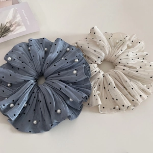 Detail of blue and beige polka dot scrunchies with pearls and soft pleated chiffon texture