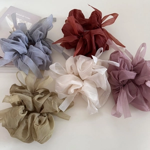Flat lay of five large sheer tulle hair scrunchies in pastel colors for bun hairstyles