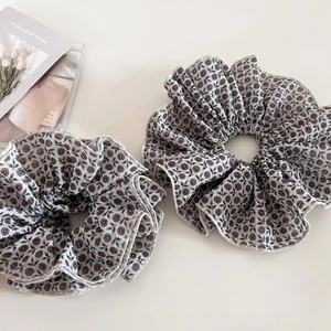 Set of two vintage floral scrunchies with purple patterns on light grey fabric