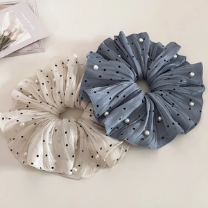 Detail of elegant ruffled scrunchies with black polka dots and white pearls