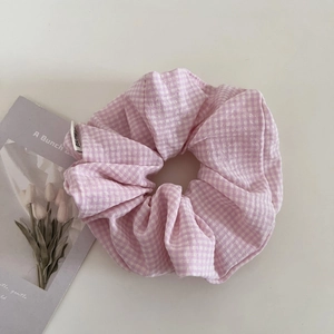 Dettaglio dell'elastico per capelli a quadretti rosa e bianchi con trama in morbido cotone