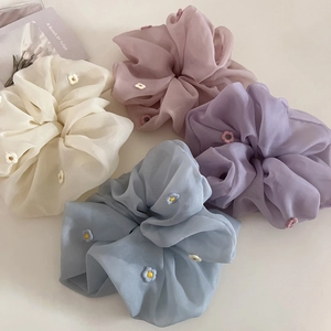 Vue détaillée de quatre chouchous en organza avec broderies florales de couleurs variées