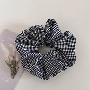 Dettaglio dell'elastico per capelli a quadretti bianchi e neri con etichetta in tessuto FMDrea