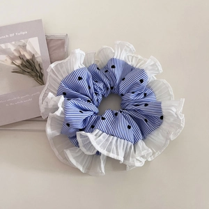 Detail of blue striped scrunchie featuring black heart prints and pleated white lace trim