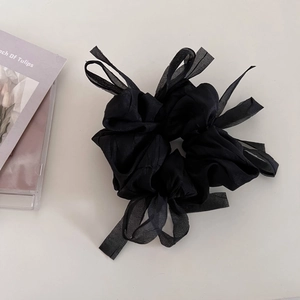 Detail of a black mesh scrunchie with soft organza bow ribbons for elegant hairstyles