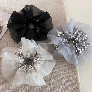 Elegant organza scrunchies with sequins in black grey and beige colors on textured mat