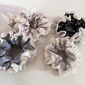 Set of four floral scrunchies with white lace edges in soft pastel colors and patterns
