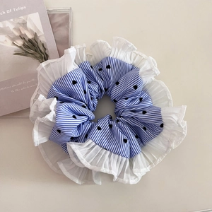 Detail of blue striped scrunchie with heart patterns and white pleated lace edges