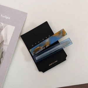 Close-up of marble pattern and translucent blue hair clips on a premium brand display card