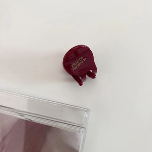 Detail view of mini wine red acetate hair claw with golden France Handmade lettering