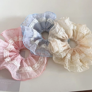 Détail des chouchous en tulle à pois avec bordure en dentelle aux tons pastel doux