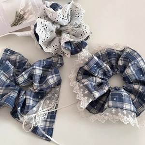 Detailed close-up of blue plaid scrunchie with white lace edges and faux pearl accents