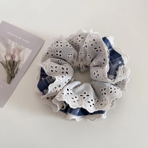 Detail of blue plaid and white lace scrunchie with layered ruffles in Korean style