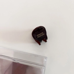Detailed macro view of small acetate hair claw clip with golden France Handmade lettering