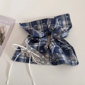 Detail of blue plaid hair scrunchie with white lace edges, pearls, and ribbon bow