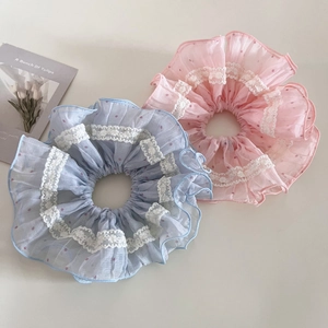 Détails de grands chouchous en maille avec pois roses et bordures en dentelle blanche