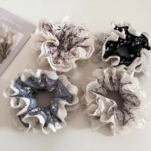 Detailed view of floral hair scrunchies with lace edges in various colors and patterns