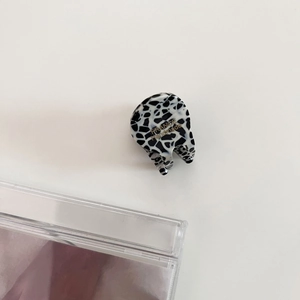 Detailed macro view of mini acetate hair claw clip with black and white shell pattern