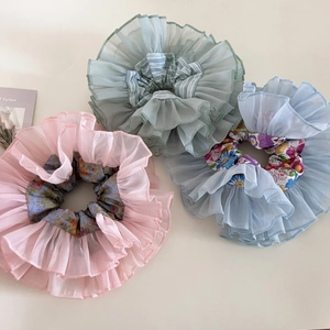 Detail of multi-layered organza floral hair scrunchies in pink, green, and blue colors