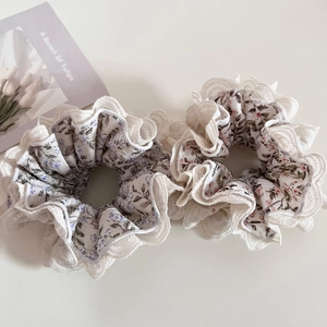 Detailed view of floral scrunchies with white lace trim for hair styling