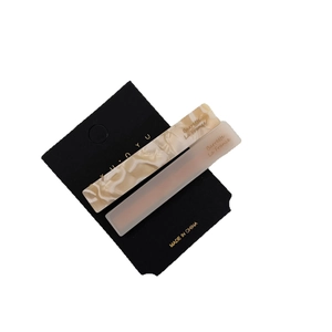 Set of two vintage marble and frosted acetate hair clips on a black display card