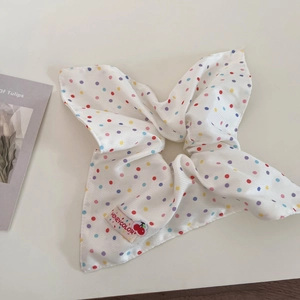 Close-up of white scrunchie with colorful polka dots and Honeycolor brand label