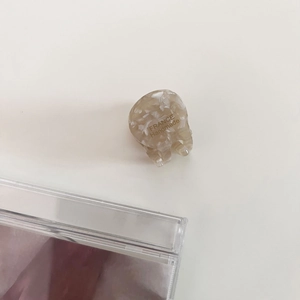Detailed macro of a cream marble acetate hair claw clip with gold handmade lettering