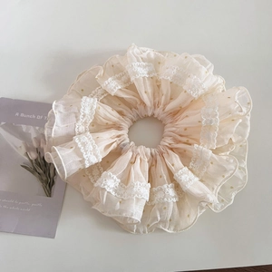 Gros plan du chouchou géant en dentelle à pois jaunes avec bords à fleurs blanches