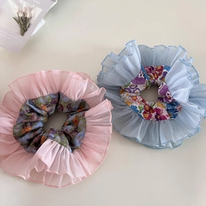 Detail of pink and light blue double-layered organza scrunchies with floral inner patterns