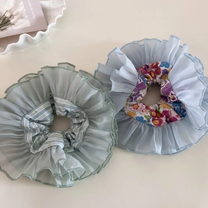 Detailed view of oversized double-layer organza scrunchies in floral and striped patterns