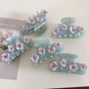 Dettaglio di cinque fermagli per capelli in acetato blu ghiaccio con fiori viola