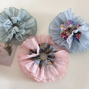Detailed close-up of organza scrunchies in pastel floral and striped fabric textures