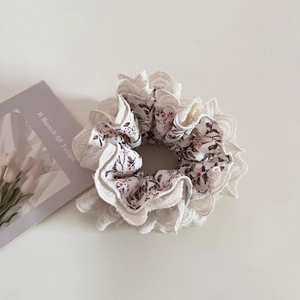 Detailed view of floral pattern lace scrunchie with delicate pink and brown flower print