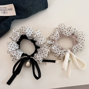 Close-up of retro polka dot chiffon scrunchies with long ribbons and pearl pendants