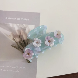 Dettaglio del fermaglio per capelli in acetato blu ghiaccio con piccoli fiori di strass