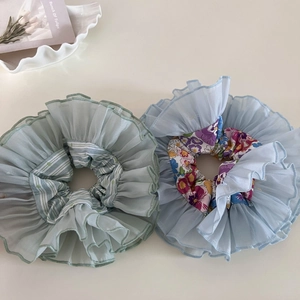 Detail of oversized double-layer organza hair scrunchies with floral and solid pleats