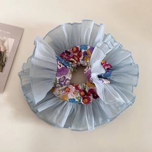Detailed macro of floral organza hair scrunchie with blue ruffled mesh edge