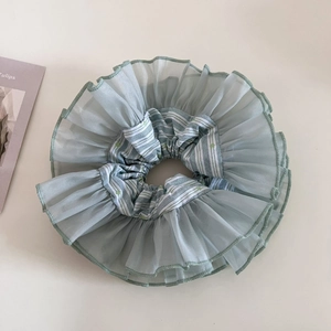 Close-up of double-layer light green organza floral scrunchie with soft ruffled texture