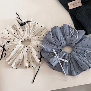 Detail of beige and blue polka dot scrunchies with elegant ribbon bow textures
