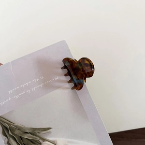 Detail shot of mini tortoiseshell hair claw clip with acetate texture on white card