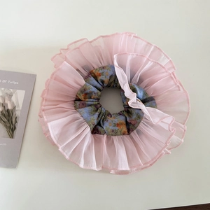 Detail of pink double-layer organza scrunchie with floral inner pattern and soft texture