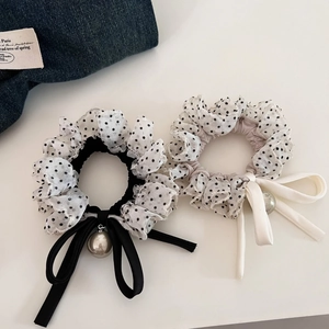 Close-up of polka dot scrunchies with lace trim, ribbons and pearl pendants