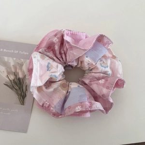 Détail d'un chouchou rose fleuri avec texture en tissu doux et plis élégants