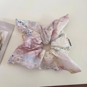 Détail d'un chouchou en patchwork de fleurs et de carreaux en tissu mousseline léger