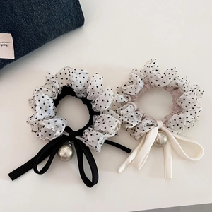 Detail of polka dot scrunchies with elegant bows and hanging pearl pendants