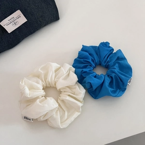 Détail de chouchous en coton blanc et bleu avec des plis et des étiquettes de marque