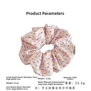 Detail of pink floral cotton scrunchie featuring delicate lace edges and brand label
