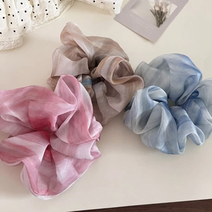 Three elegant ink-wash organza scrunchies in pink, blue, and brown with marble texture