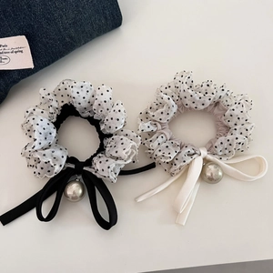 Detailed shot of black and white polka dot mesh hair scrunchies with large pearl charms