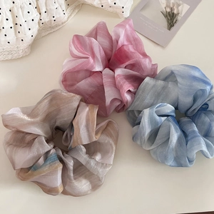 Detailed view of marble ink print organza scrunchies in pink, blue and brown gradients